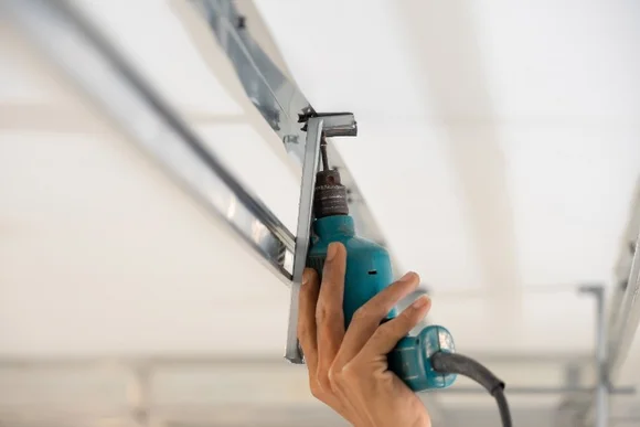 Hand befestigt Metallprofil mit Bohrmaschine